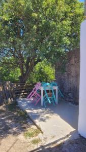 una mesa y sillas sentadas bajo un árbol en Fournos Aroniadika en Kýthira