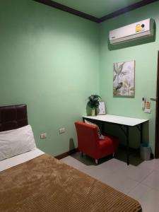 una camera con letto, scrivania e sedia rossa di Passion Nai Harn a Nai Harn Beach