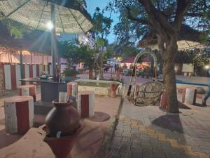 an outdoor area with a large vase and an umbrella at Chola Heritage Resort in Kāraikkudi