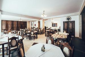 una sala da pranzo con tavoli e sedie in un ristorante di Conacul Domnitei a Gura Humorului Altre 28 foto