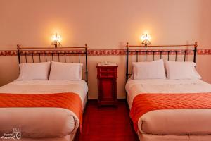 - deux lits assis l'un à côté de l'autre dans une pièce dans l'établissement Hostal Colonial Potosi, à Potosí
