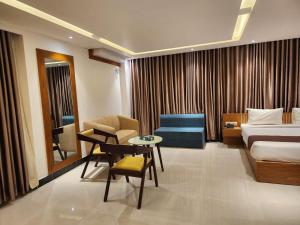 pokój hotelowy z łóżkiem, stołem i krzesłami w obiekcie Sea Paradise w mieście Koks Badźar