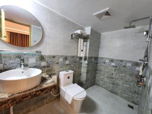 W łazience znajduje się umywalka, toaleta i lustro. w obiekcie Sea Paradise w mieście Koks Badźar