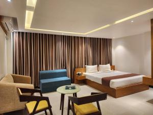 Pokój hotelowy z łóżkiem i krzesłem w obiekcie Sea Paradise w mieście Koks Badźar