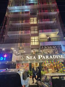 un grand bâtiment avec un panneau de défilé en bord de mer dans l'établissement Sea Paradise, à Cox's Bazar