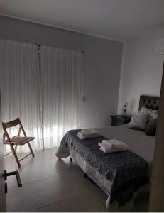 1 dormitorio con 1 cama con 2 toallas en Moderno Departamento en Luján de Cuyo cercano a bodegas y viñedos en Luján de Cuyo