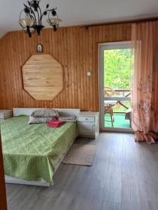 a bedroom with a bed and a sliding glass door at Садиба "Наталі" in Yaremche