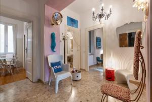 - un salon avec une chaise et une table dans l'établissement Billie's Flat WHITE - art & design apt in Verona historic centre, à Vérone