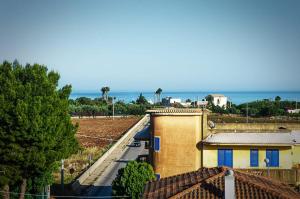 een uitzicht op een gebouw met de oceaan op de achtergrond bij Sunrise Luxury Apartments in Cassibile