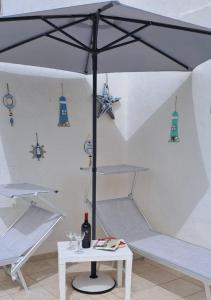 a white room with a table and an umbrella at Cinque terrazze - Casa d'epoca con vista mare in Gallipoli