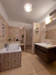 duża łazienka z wanną i umywalką w obiekcie Fehér szeder w mieście Csopak