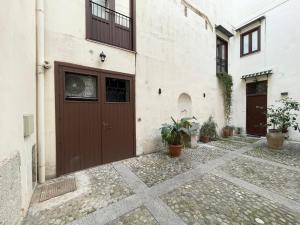 un edificio con una porta marrone e alcune piante di Nel Cuore di Palermo Isidoro Palace a Palermo