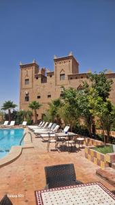 斯库拉Kasbah Ait BenHadda的一个带游泳池和椅子的度假胜地和一座建筑