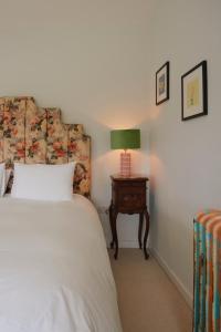 a bedroom with a bed and a table with a lamp at Molly's Cabin, Countryside Stay in Sutton Bonington
