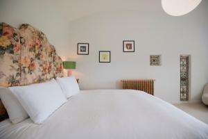 a bedroom with a white bed with a floral headboard at Molly's Cabin, Countryside Stay in Sutton Bonington