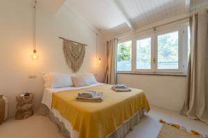 a bedroom with a bed with a yellow blanket at Villa Morea & Rooms in Procida in Procida