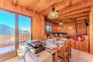 a dining room with a table and a large window at Chalet Altitude - Vue panoramique - 8 pers in Bernex