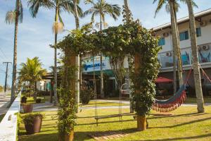 um jardim em frente a um edifício com palmeiras em Hotel Villareal Guaratuba - Caieiras em Guaratuba