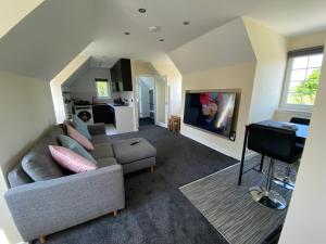 uma sala de estar com um sofá e uma mesa em WHITEHILL STABLES em Kirknewton