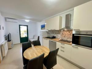 a kitchen with a wooden table and black chairs at Guest House Donatela in Valun