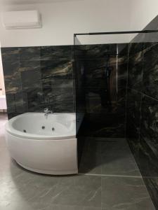 a bathroom with a bath tub and a sink at Hotel Albatros in Prizren