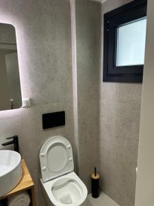 een badkamer met een wit toilet en een wastafel bij Kiani Akti Suites 2 in Preveza +8 foto's
