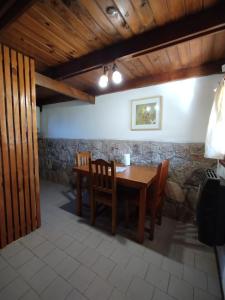 ein Esszimmer mit einem Holztisch und Stühlen in der Unterkunft La cumbrecita village in La Cumbrecita