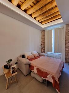 a bedroom with a large bed and a couch at Antiquari de Blanes Apartamento rústico modernizado en la Costa Brava in Blanes