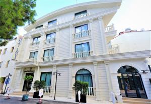 a large white building with trees in front of it at Mai İnci Otel in Antalya
