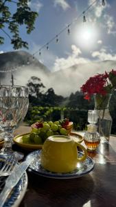 a table with a plate of food and a bowl of fruit at Pousada paraíso pedra do Rodeadouro in Bonito