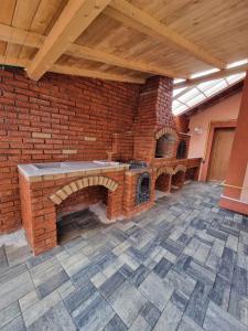 uma parede de tijolos com um forno de tijolos num quarto em Pensiunea Eric em Curtea de Argeş
