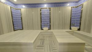 a large room with two toilets and blue tiles at Mai İnci Otel in Antalya