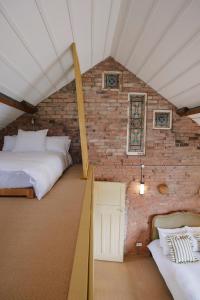 a room with two beds in a brick wall at Beautiful Countryside Farmhouse in Sutton Bonington