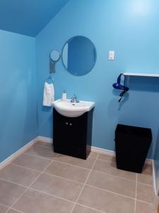 uma casa de banho com um lavatório e uma parede azul em Dans les draps de Morphee em Campbellton