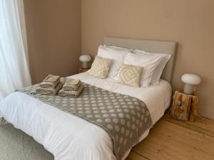 sypialnia z dużym łóżkiem z białą pościelą i poduszkami w obiekcie Les chambres de la Villa Oberlin w mieście Beblenheim