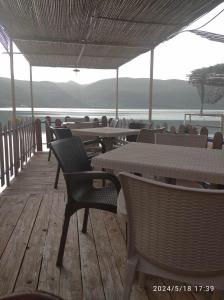 un restaurante con mesas y sillas y vistas al agua en ERDA LAKESIDE Guesthouse en Lin