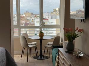 a living room with a table and chairs and a window at Riscal Suits Luxury in Alicante