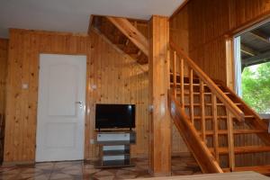 una sala de estar con escalera y TV en una casa en Pobierowo Dom 100m2 z działką en Pobierowo