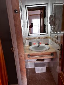 uma casa de banho com um lavatório e um espelho em Apartamentos Inter Gandia Playa em Playa de Gandia