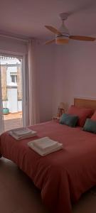 - une chambre avec un lit rouge et des serviettes dans l'établissement Ático jacuzzi Cómpeta, à Cómpeta