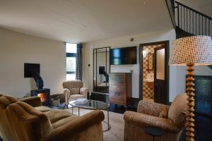 a living room with a couch and chairs and a fireplace at The Grain Store in Sutton Bonington