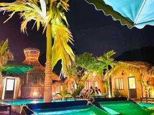a resort with a swimming pool at night at Tam Coc Sky Bungalow in Ninh Binh