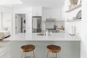 a kitchen with a white counter and two stools at Northeka208 in Quebec City