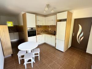 a kitchen with a white table and a white refrigerator at Casa Lucia in Ocnele Mari