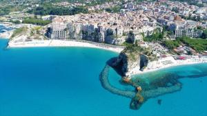Santa Venere Apartments "Parcheggio privato" في تروبيا: اطلالة جوية على شاطئ به ماء ازرق