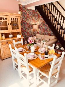 a dining room with a table and white chairs at Overleigh Cottage, with optional Hot Tub hire in Chester