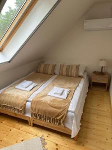 1 dormitorio con 1 cama con 2 toallas en Öböl Liget vendégházak, en Abádszalók