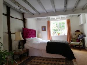 ein Schlafzimmer mit einem großen Bett und einem Fenster in der Unterkunft Michaelmas Cottage Upavon in Upavon