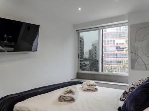 Un dormitorio con una cama y una ventana grande. en Moderno 2BR Center Miraflores- Balta 301, en Lima