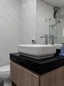 Un baño con un lavabo blanco y un inodoro. en Moderno 2BR Center Miraflores- Balta 301, en Lima